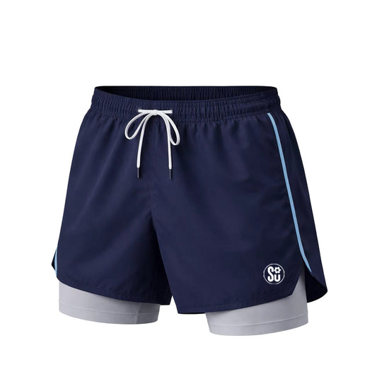 The RUN PRO Short by Southern Apparel features navy blue running shorts with a white drawstring, light blue side stripes, a white logo on the left leg, and built-in light gray compression shorts in lightweight performance fabric.